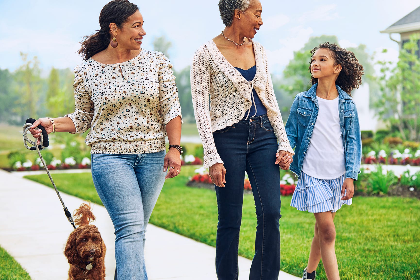 women of three generations enjoying a walk together with dog