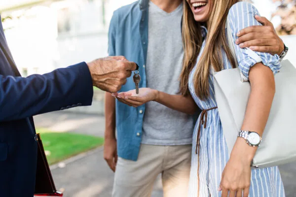 Young happy couple talking with real estate agent and buying a n